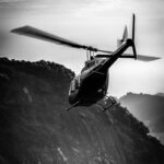 A black and white image of a helicopter in flight, capturing the essence of a thrilling Valentine's Day experience over Adelaide's scenic landscapes, perfect for adventurous couples seeking an unforgettable date.