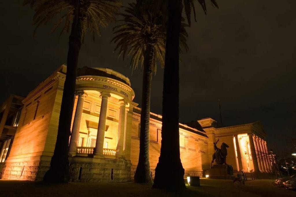 Nighttime view of the Art Gallery of New South Wales lit up, showing the cultural vibrancy and the pros of living in Sydney, offering a rich arts scene and historic architecture.