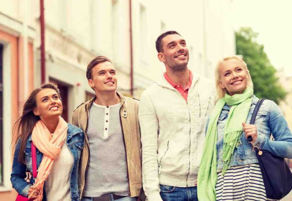 A cheerful group of friends enjoying a walking tour in Sydney, looking around and taking in the sights.