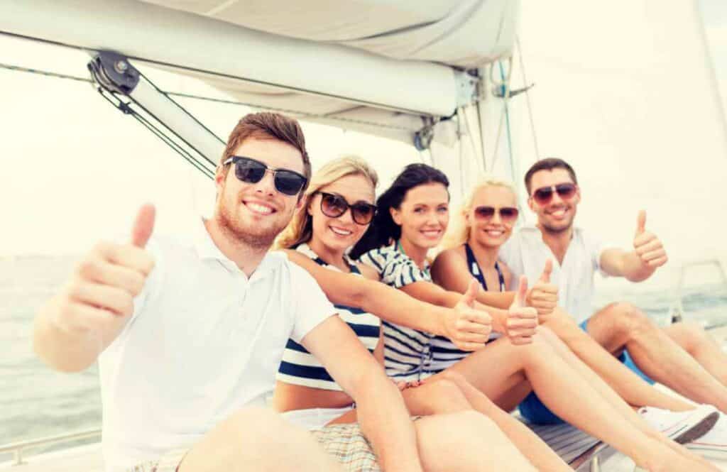 Group of cheerful friends giving thumbs up on a sunny day during a private boat tour in Sydney, reflecting the enjoyable and personal experience offered on the water