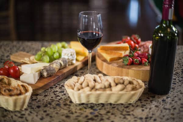 Wine bottle and glass paired with a variety of food, illustrating the gourmet experience on Yarra Valley wine tours from Melbourne