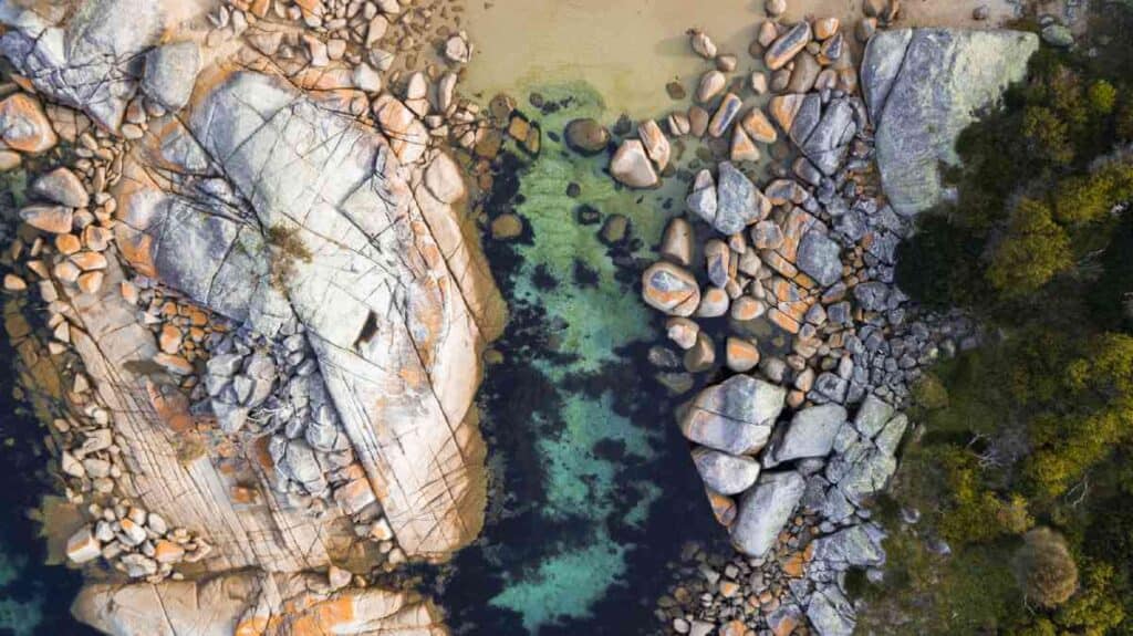 Aerial view of Bay of Fires in Binalong Bay, Tasmania, showcasing rocky landscapes and clear waters, a scenic spot for photography enthusiasts.