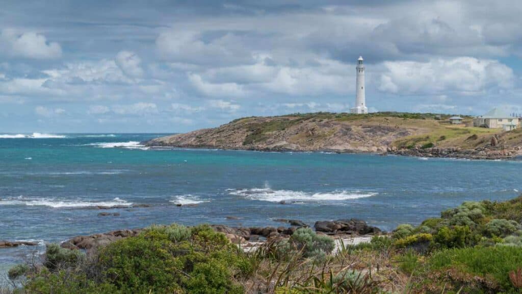 View of Cape Leeuwin lighthouse on a rocky coast in Western Australia, a scenic spot on a road trip Australia.
