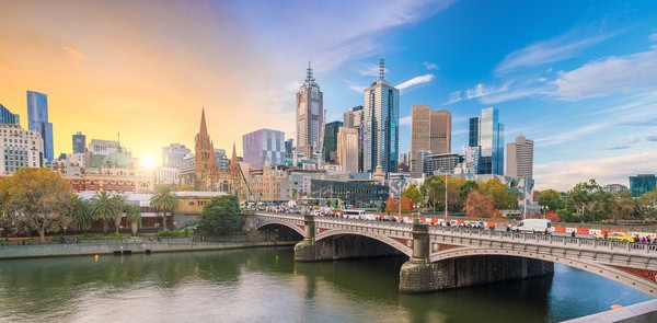 Melbourne's vibrant city skyline at twilight, with modern skyscrapers and historic buildings reflecting on the Yarra River. This image relates to the question 'Are Melbourne and Victoria the same?' by highlighting Melbourne as the capital city within the state of Victoria.