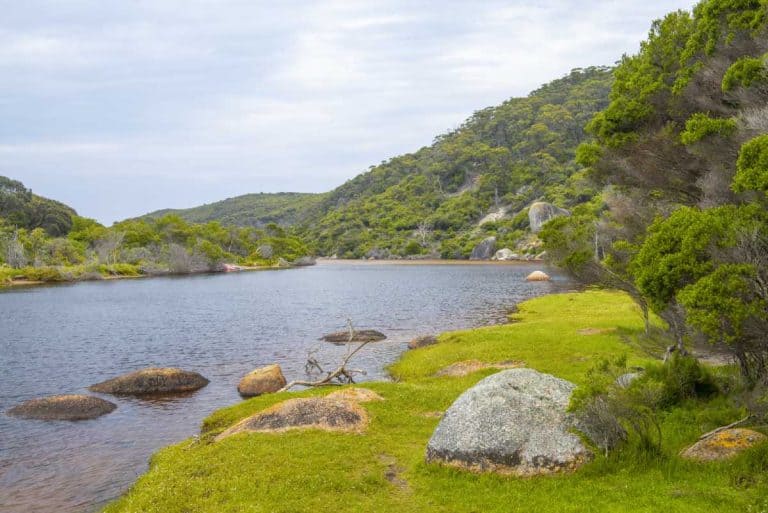 Tidal River at Wilsons Promontory surrounded by lush greenery and rocks, showcasing its natural beauty but highlighting its reputation as one of the worst camping spots for families in Australia due to overcrowding, noise, and limited child-friendly amenities.