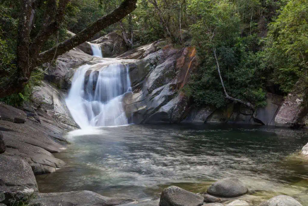 Josephine Falls in Queensland, Australia, a serene natural cascade surrounded by lush greenery, a perfect spot for a refreshing swim or picnic during Cairns in winter.