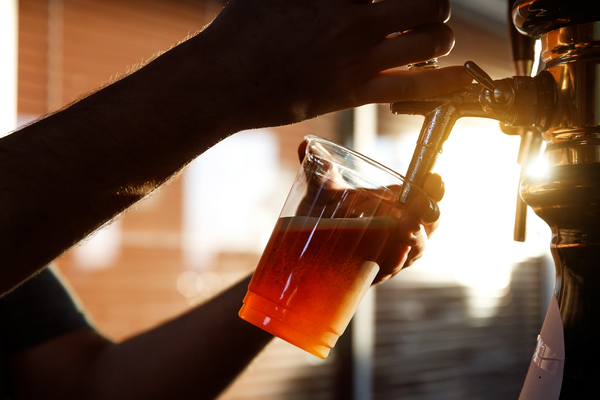 pouring beer into a plastic glass 