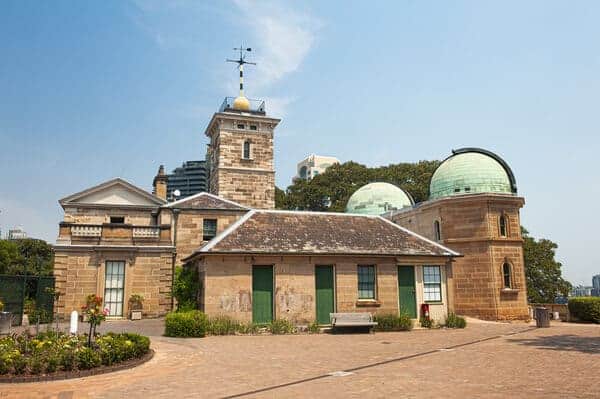 The Sydney Observatory on a sunny day, with its historic stone architecture and distinctive green-domed telescope rooms. As a place of science and stars, it's also woven into the fabric of tales and legends told on Sydney ghost tours.