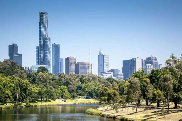 Melbourne's skyline viewed from a park by the Yarra River, symbolizing the fusion of nature and urbanization. This setting prompts the inquiry 'where does the name Melbourne come from?' discussed in the blog post, highlighting the city's evolution and historical roots.