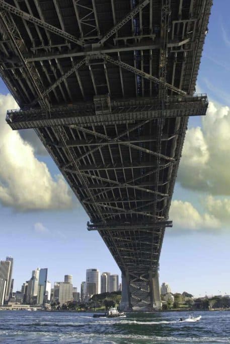 Underside view of the Sydney Harbour Bridge illustrating its robust steel framework, as a testament to the bridge's engineering, relevant to discussing the impressive weight capacity the Sydney Harbour Bridge can support.