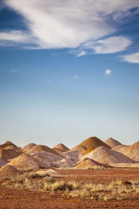 Mound formations in the arid landscape of Coober Pedy, showcasing the unique scenery found on Australian road trips.