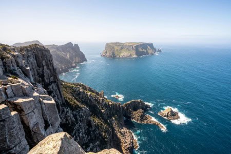 The rugged cliffs of the Tasman Peninsula stretch out into the sea, offering breathtaking views for nature lovers on a Valentine's Day adventure in Hobart, Tasmania.