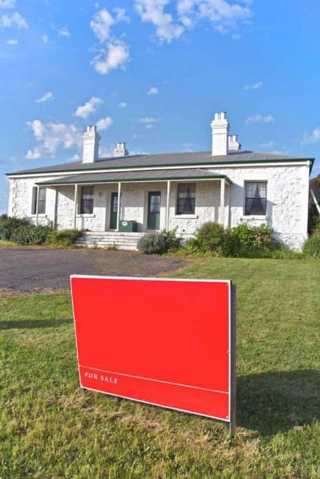 Traditional Tasmanian cottage with a 'For Sale' sign, highlighting the affordable housing market as one of the key advantages of living in Tasmania.