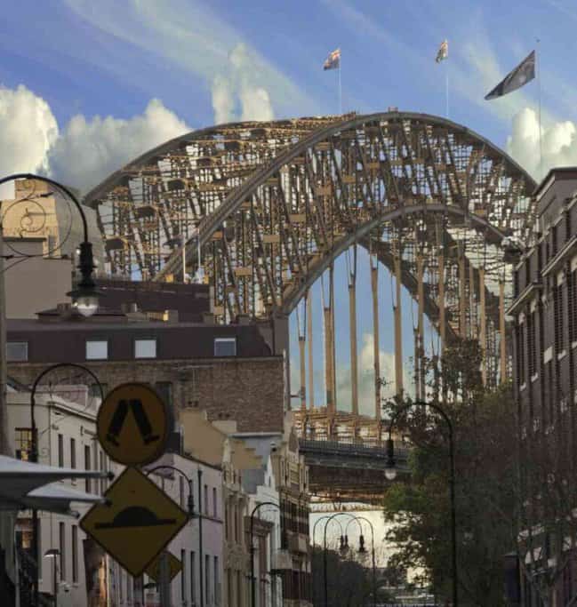 View of the Sydney Harbour Bridge as seen from The Rocks, bustling with activity from Sydney walking tours.