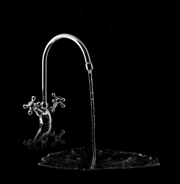 Water tap on black background