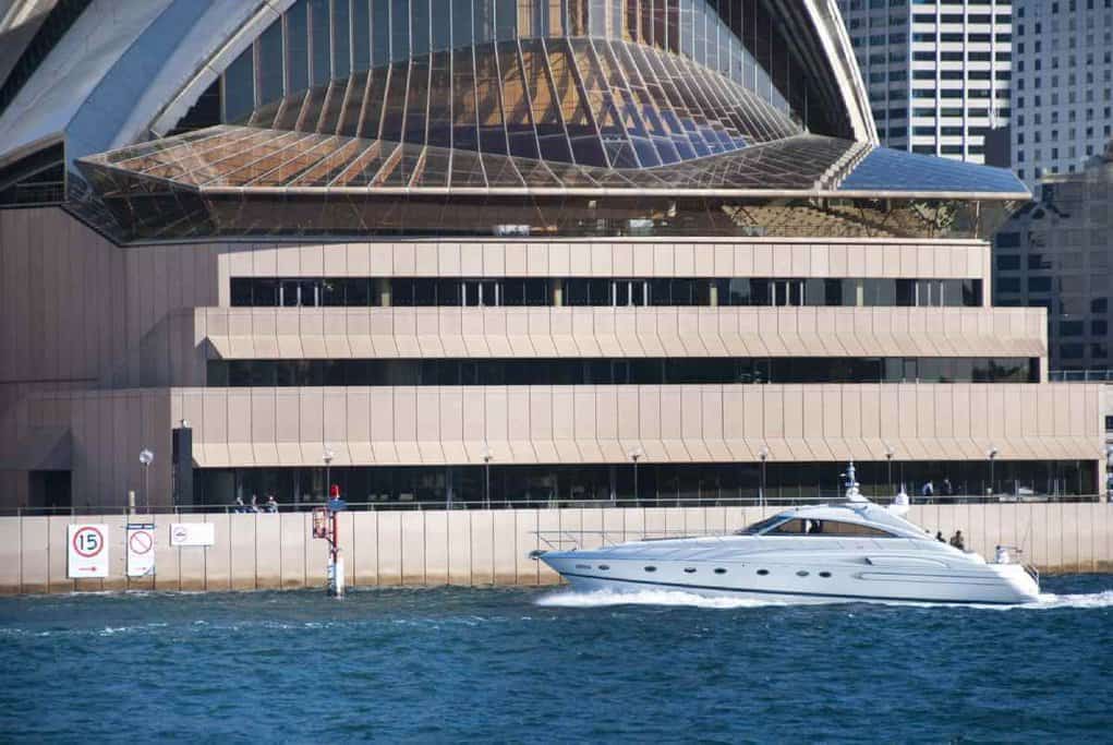 A luxury yacht from a Sydney private boat tour sails near the Sydney Opera House, highlighting the opulent and exclusive boating experiences available in Sydney.