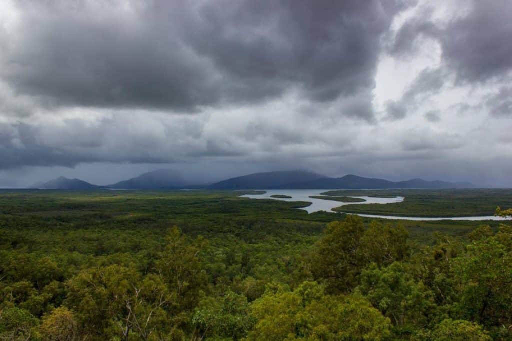 Aerial view of the lush greenery and winding waterways of Barron Gorge National Park in the Atherton Tablelands under cloudy skies. Showcasing the area's stunning natural landscapes, this image highlights one of the top reasons to visit the Atherton Tablelands, known for its World Heritage-listed beauty.