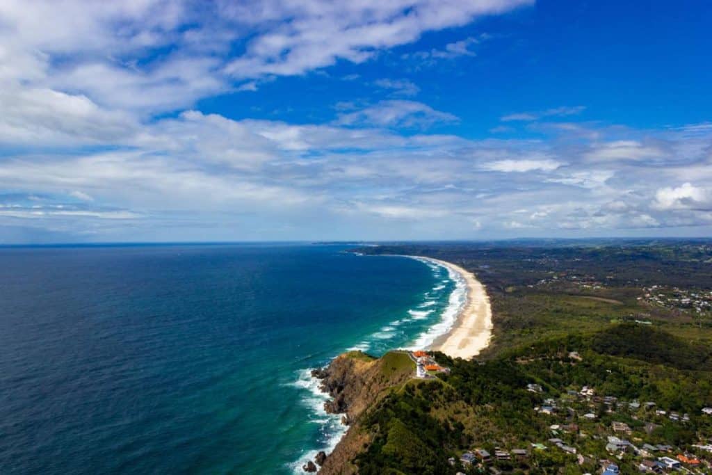 Aerial view of Wategos Beach and Cape Byron Lighthouse, showing the pristine coastline and lush greenery of Byron Bay. This image highlights the scenic beauty and iconic landmarks of the area, tying into the blog's focus on exploring Cape Byron's natural and historic attractions.