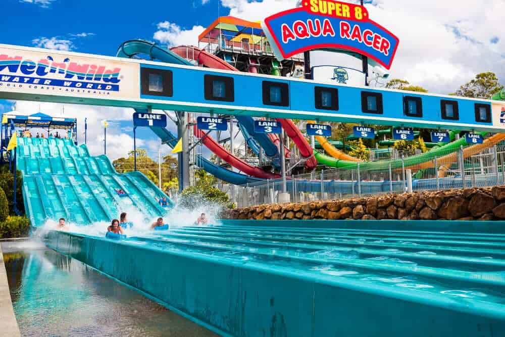 Exhilarated riders splash down the vibrant blue lanes of the Super 8 Aqua Racer at Wet'n'Wild Gold Coast, a highlight featured in our detailed review of the water park's attractions.