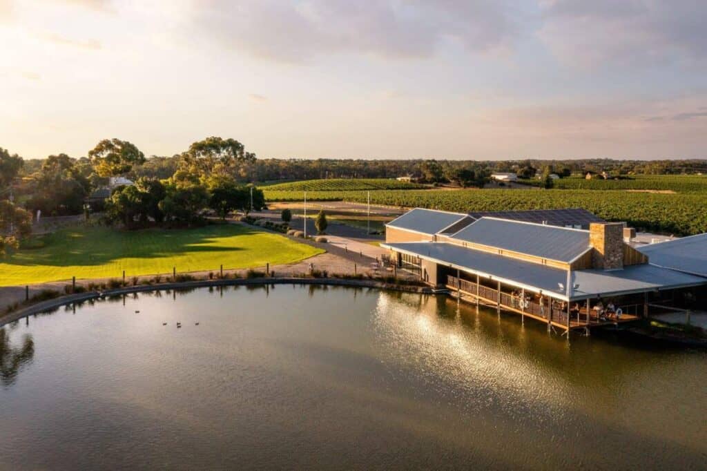 Aerial view of Barossa Valley Chocolate Company surrounded by lush vineyards and a tranquil pond, illustrating one of the enjoyable activities in Barossa Valley where visitors can indulge in locally made chocolates and scenic views.