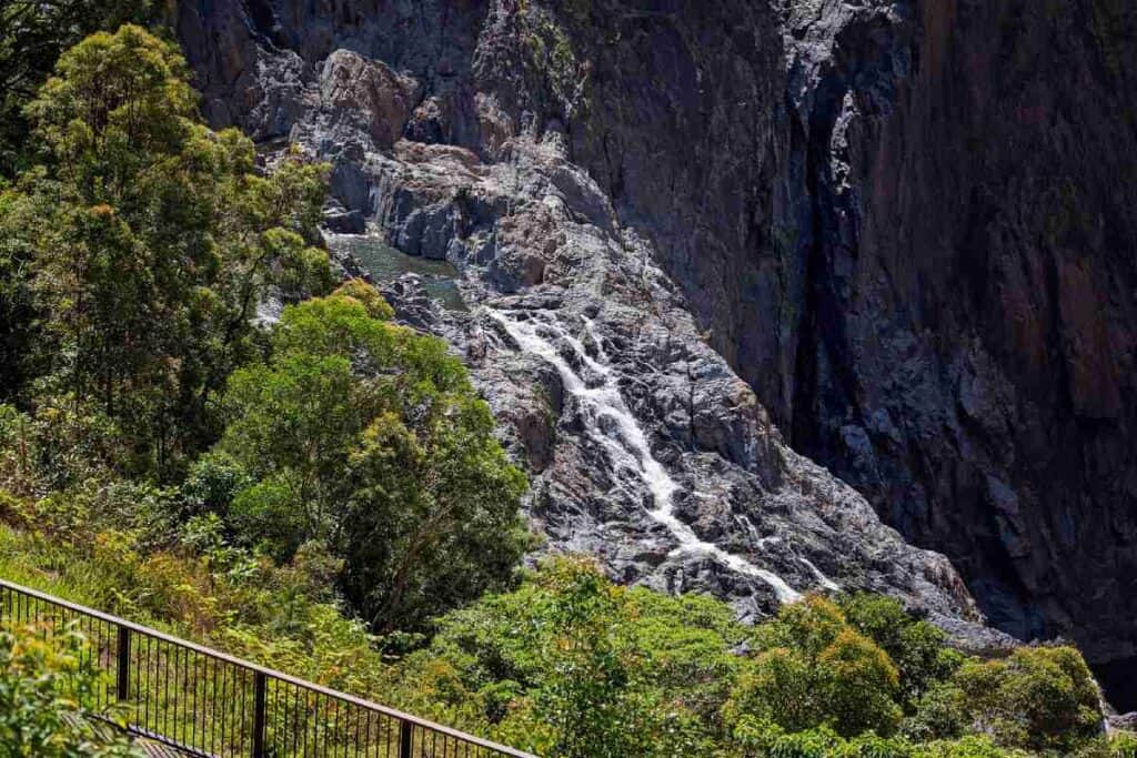 Barron Falls in Queensland, a striking example of Australia’s horizontal waterfalls, with water cascading over rocky cliffs in a series of stepped drops, surrounded by lush greenery, illustrating the diverse and dramatic landscapes of Australian waterfalls.