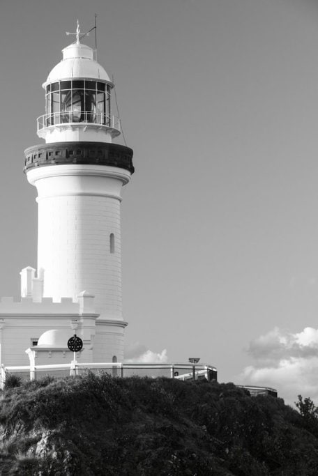 Close-up of Cape Byron Lighthouse, showcasing its iconic white facade and intricate architecture against a clear sky. This image highlights the historic significance and architectural beauty of one of Australia’s most famous lighthouses.