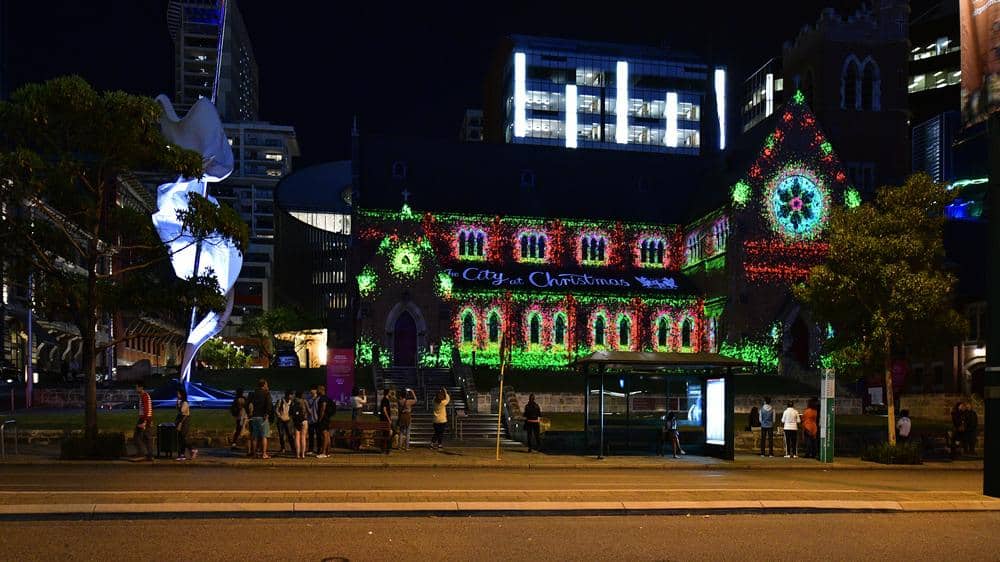 Historic building in Perth illuminated with colourful Christmas lights and a 'City at Christmas' sign, creating a festive atmosphere in the city. Showcases the vibrant decorations and community spirit of Christmas in Perth.