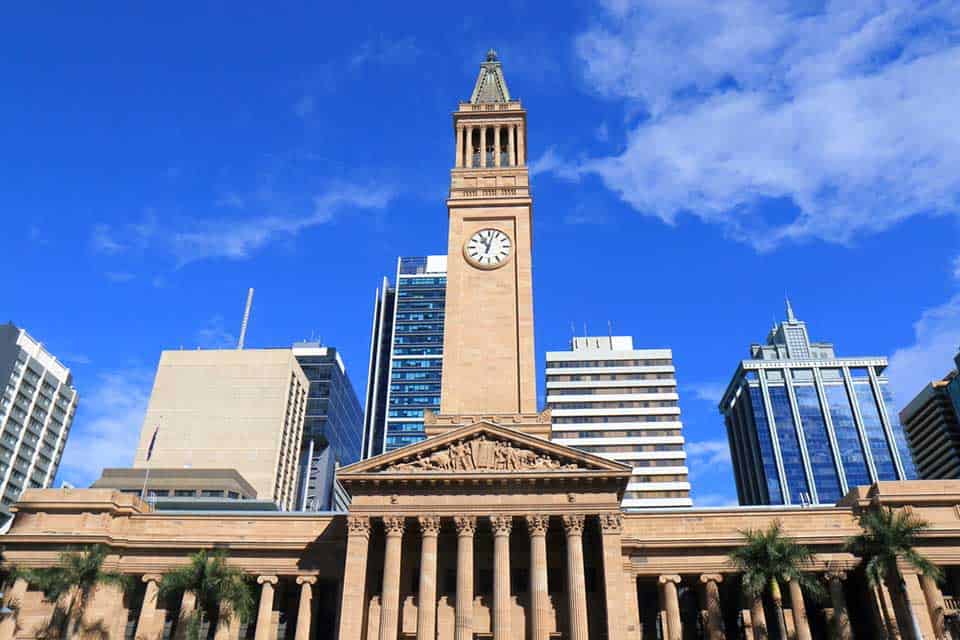 Front view of Brisbane's City Hall Museum with its prominent clock tower, showcasing a key attraction in the Sydney or Brisbane comparison.
