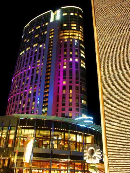 Exterior of Crown Hotel illuminated at night, a popular destination for Christmas lunch in Melbourne, offering luxury dining and festive experiences for the holiday season.