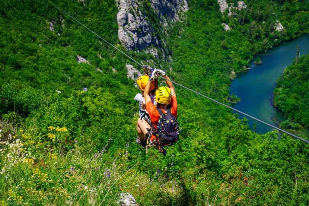 Adventurers zip-lining over the lush canopy of the Daintree Rainforest, offering a thrilling eco-tourism experience that showcases the natural beauty and adventurous spirit of Port Douglas and Cairns travel.