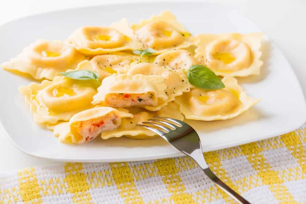 A plate of freshly prepared ravioli garnished with basil, a delightful Italian dish that's often enjoyed on Sydney foodie tours.