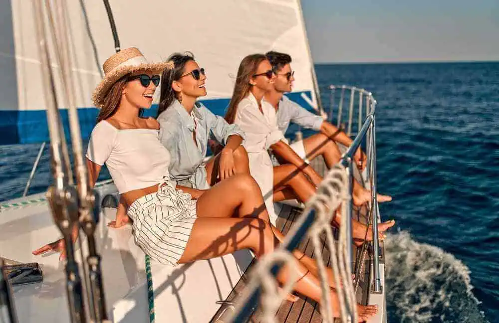 Group of friends enjoying a sunny day aboard a yacht on a Sydney boat private tour, with the ocean stretching out around them.