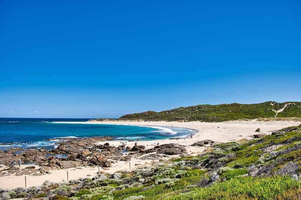 Breathtaking coastal scenery with a mix of beach, rocks, and shrubbery at Margaret River, a perfect winter escape for those looking for serene beachside activities.