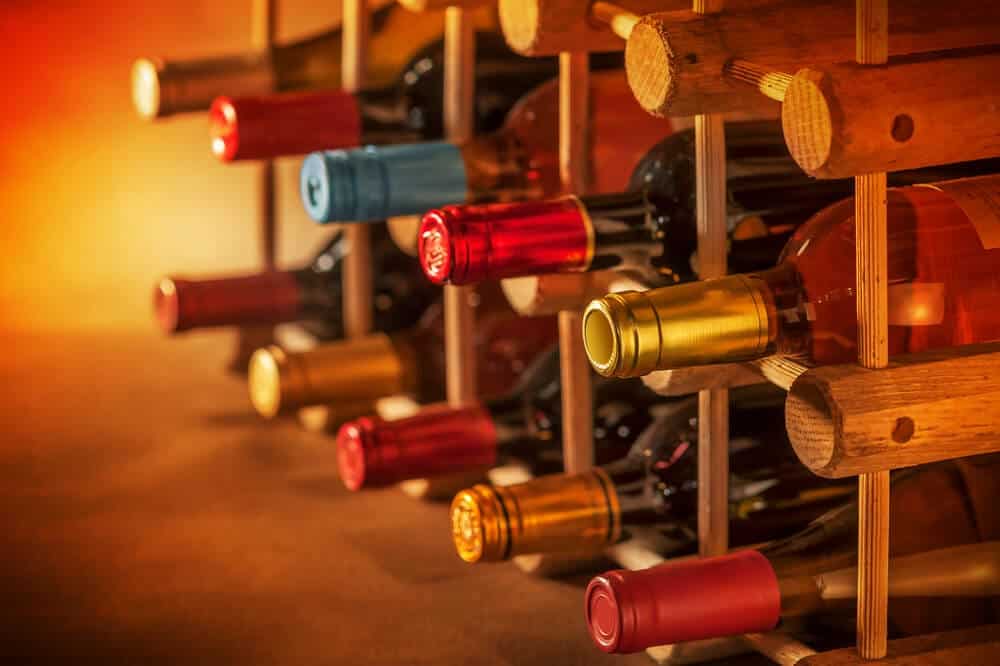An array of wine bottles in a wooden rack showcasing red, white, and rosé options, highlighting the variety found on wine tours in Hobart.