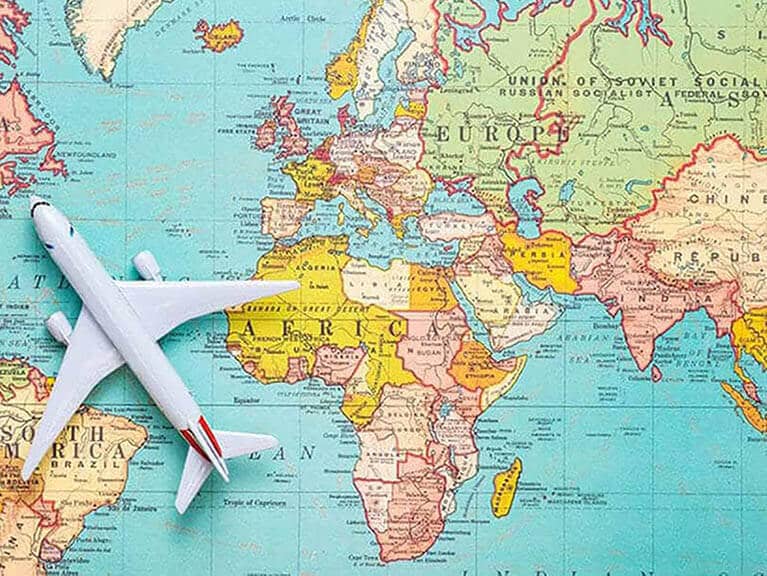 World map featuring a plane in flight, symbolising the geographical distance and travel considerations discussed in the post exploring if Australia is part of Europe.