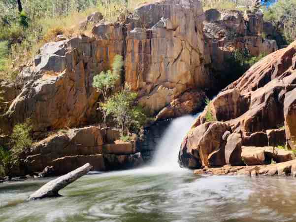 Serene view of Fish Falls in the Grampians, with water cascading through a rock-strewn channel into a tranquil pool, a must-visit for nature lovers exploring the park.