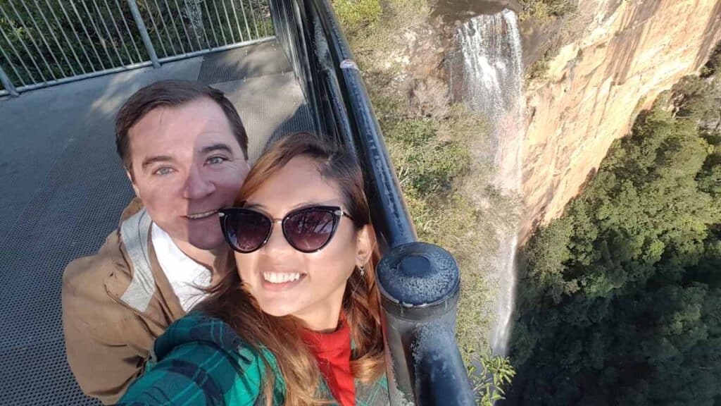 The author and her husband taking a selfie at the lookout above Fitzroy Falls in New South Wales, one of the popular waterfalls in Australia, highlighting the joy of exploring Australia's stunning natural attractions.