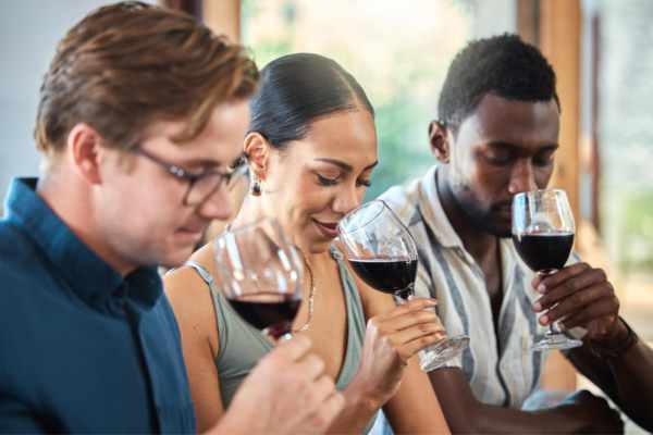 Group of people holding and smelling wine.