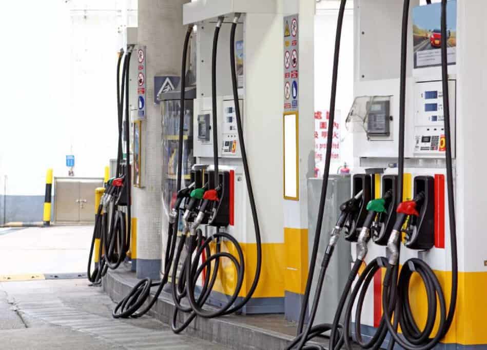 A gas station with several fuel pumps, each equipped with hoses and nozzles in various colours, typically representing different types of fuel. Australian slang word 'servo' refers to a gas station or service station.