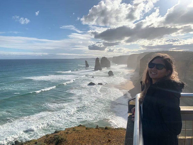 Photo of me standing in front of the 12 Apostles, showcasing one of the iconic landmarks that make Melbourne worth visiting.