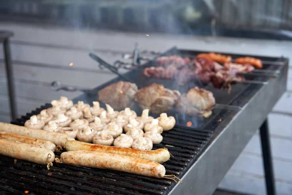 Grilling assorted BBQ meat, sausages, and vegetables, a common sight during Christmas in Australia. One of the interesting facts about Christmas in Australia is that many families celebrate the holiday with outdoor barbecues, taking advantage of the warm summer weather.