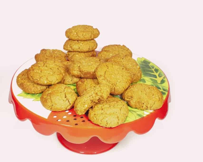 A plate of homemade Anzac biscuits, a classic Australian treat made with oats, golden syrup, and coconut. These crunchy, golden biscuits have deep historical significance and remain a staple in Australian food culture.