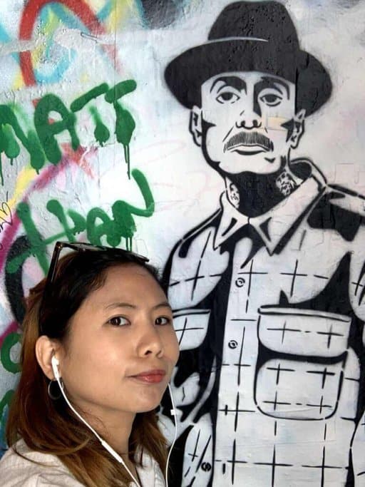 Kate posing next to a detailed black and white mural in Melbourne's famous Hosier Lane. The vibrant graffiti and street art make this one of the most Instagrammable places in Melbourne, perfect for capturing unique and artistic photos.