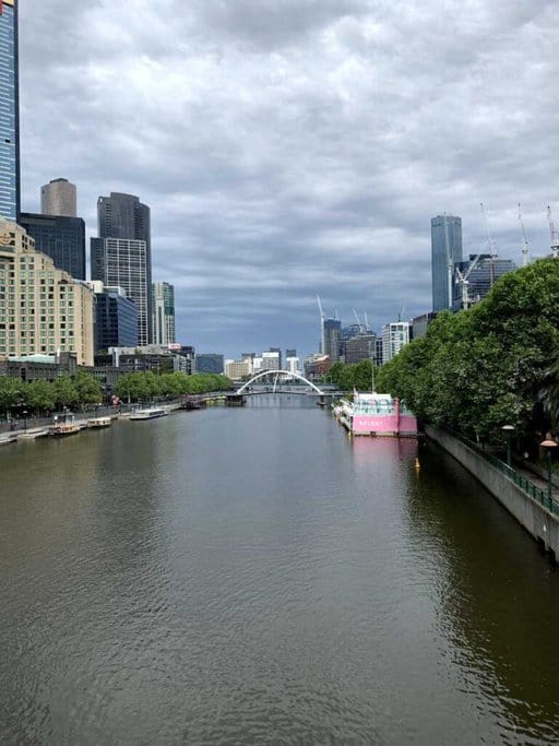 A view of the Yarra River in Melbourne, showcasing the city skyline and the iconic Princes Bridge in the distance. This scene is one of the Best Melbourne's Instagrammable Spots, offering picturesque views perfect for capturing the essence of the city.