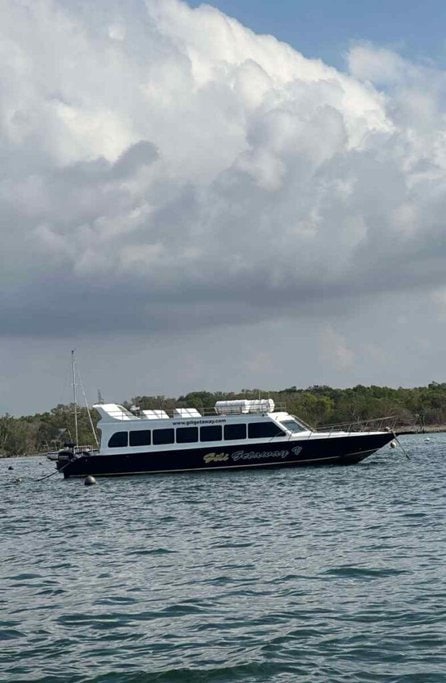 The Gili Getaway fast boat moored in calm waters off the coast, ready to transport passengers on the popular route from Bali to the Gili Islands.