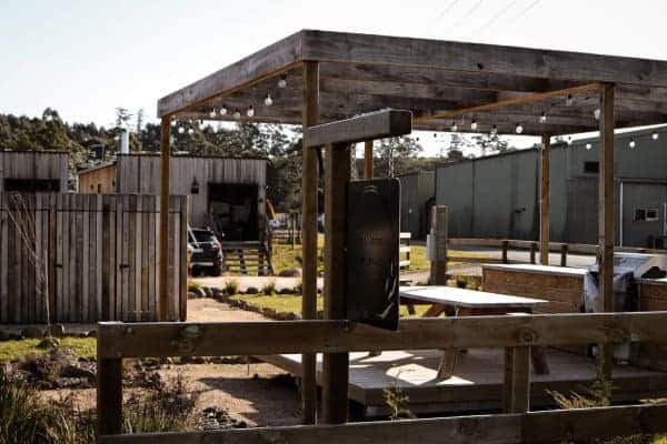 A rustic outdoor setting with a wooden pergola at an upscale cabin situated near Derby, showcasing the cabin's blend of luxury and natural charm, perfect for guests who appreciate refined comfort in a tranquil environment.