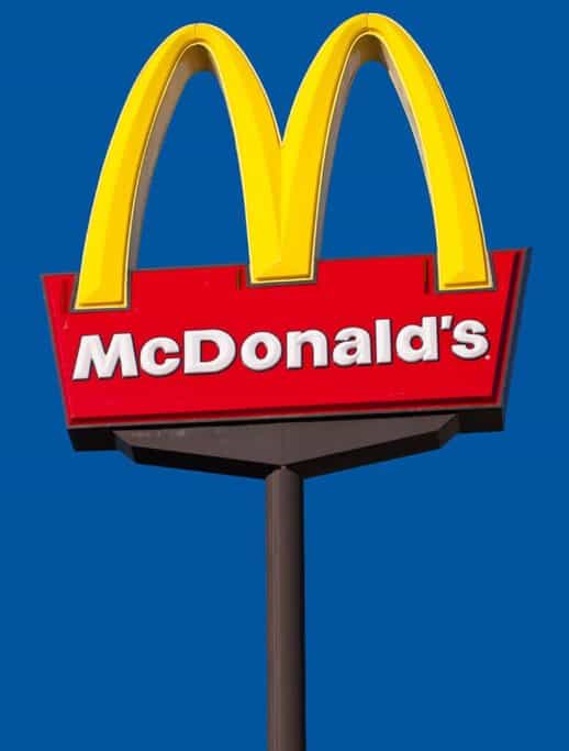 The iconic McDonald's sign, featuring the large golden arches with the red backdrop and white "McDonald's" text below. In Australia, McDonald's is commonly referred to as "Macca's," a popular Australian slang word used across the country.