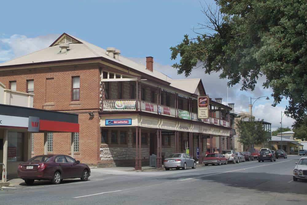 A view of the main street in Tanunda, Barossa Valley, showing heritage-style buildings, local shops, and parked cars—capturing the small-town charm and slower pace often discussed when weighing the pros and cons of living in Barossa Valley.