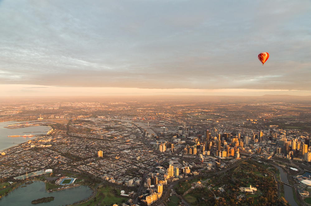 a hot air balloon floating over the central business district of melbourne