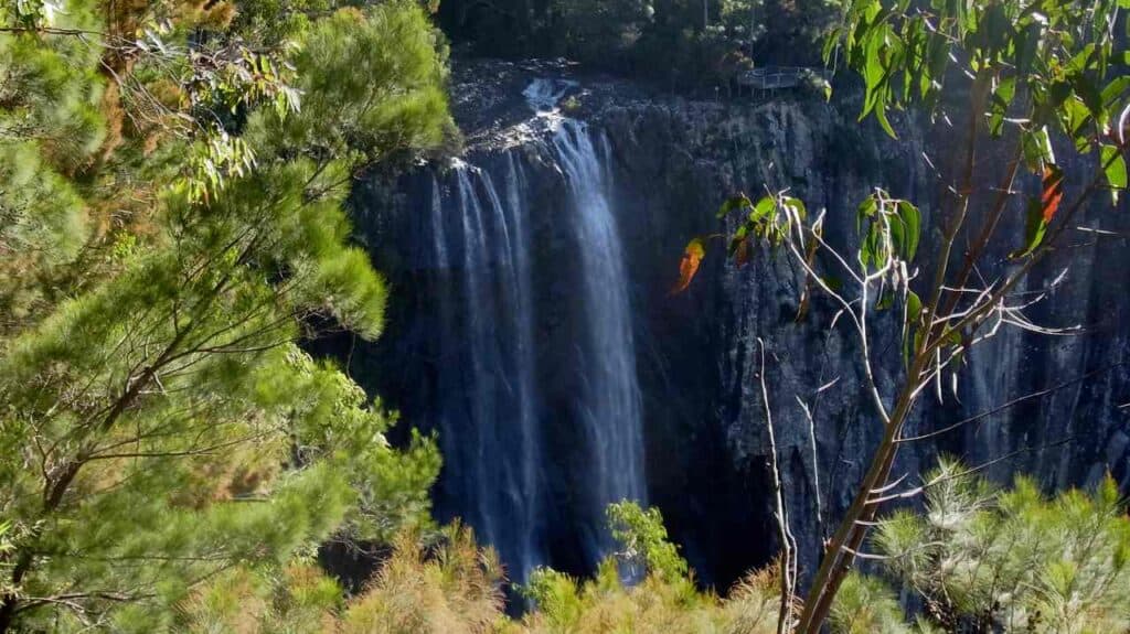 Minyon Falls cascading down a rocky cliff surrounded by lush greenery, showcasing one of the top natural attractions and things to do in Byron Bay.